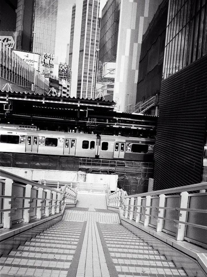 Train crossing between skyscrapers, Japan — street photograph by Marco Miraglia