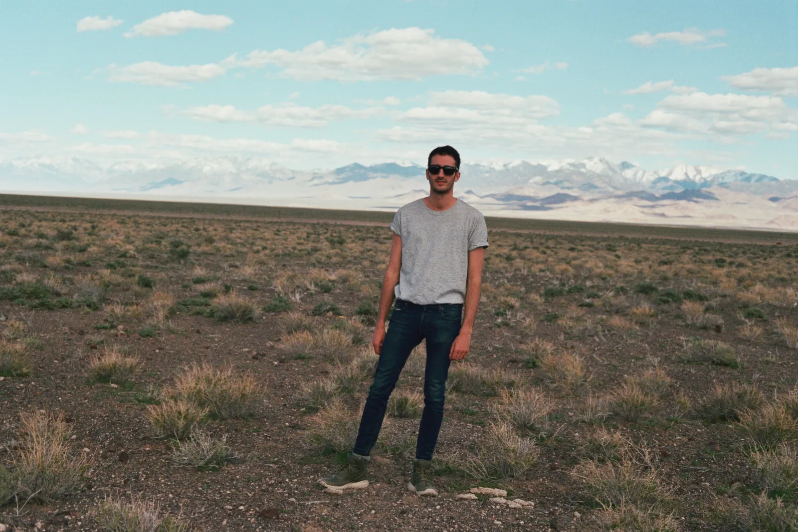 Marco Miraglia standing in the American desert, snow-capped mountains on the horizon — 35mm film photo