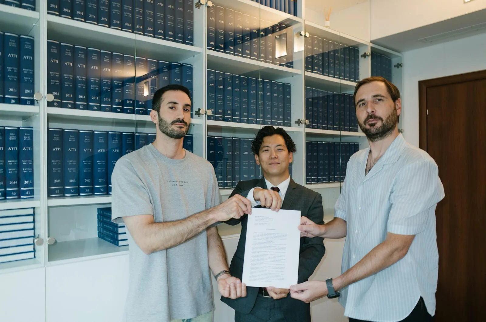 Marco Miraglia with Mario Toyoshima and Davide Caselli holding the incorporation deed of Edera at the notary