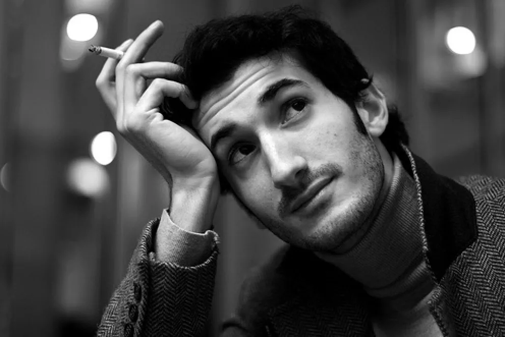 Marco Miraglia in a Paris café, tweed coat and turtleneck — black and white snapshot